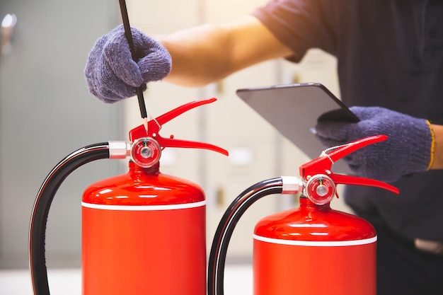 Der Feuerlöscher hat einen Handingenieur, der Manometer überprüft