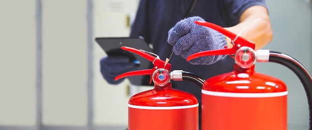 Der Feuerlöscher hat einen Handingenieur, der Manometer überprüft