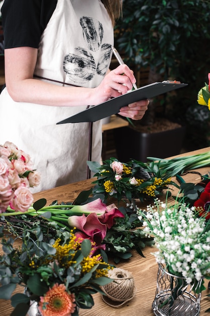 Foto der florist zählt und zeichnet blumen auf