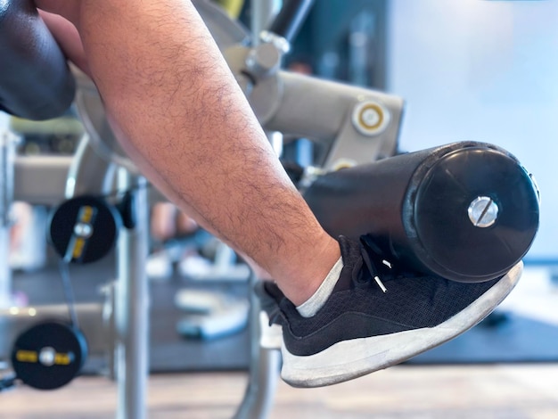 Der Fokus auf den männlichen Beinen liegt auf der Verwendung eines Trainingsgeräts, um die Muskeln in den Beinen zu straffen.
