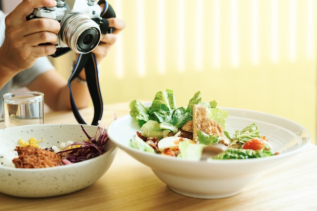 Der Fotograf fotografiert einen Teller mit Caesar-Salat