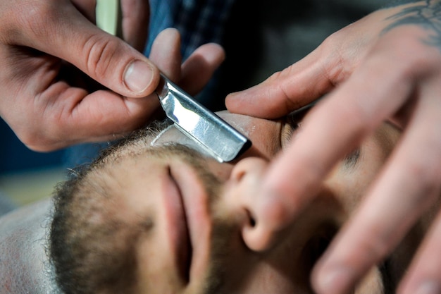 Foto der friseur schneidet den bartmann