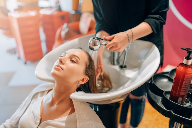 Der Friseur wäscht Kundenhaare im Becken und im Friseursalon.