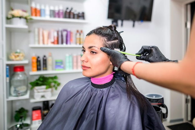 Der Friseur wendet professionelles flüssiges Keratin auf das Haar des Kunden an Ein Mädchen macht Keratin-Haarstärkung in einem Schönheitssalon Haarpflege