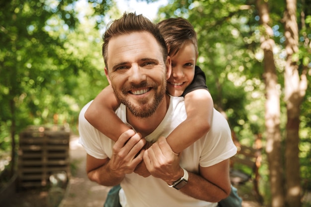 Der fröhliche junge Vater hat Spaß mit seinem kleinen Sohn