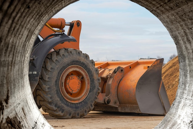 Der Frontlader nimmt Kies oder Schotter in der Frontschaufel auf Schwere Baumaschinen auf der Baustelle Materialtransport in einem Betonwerk