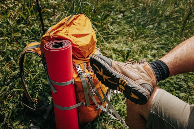 Foto der fuß eines touristen neben seinem rucksack, der auf einer einzelreise unterwegs ist, um sich zu verbinden