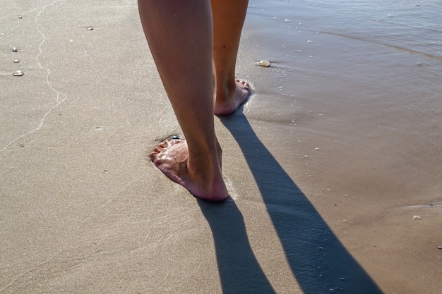 Der Fuß ist auf dem nassen Sand