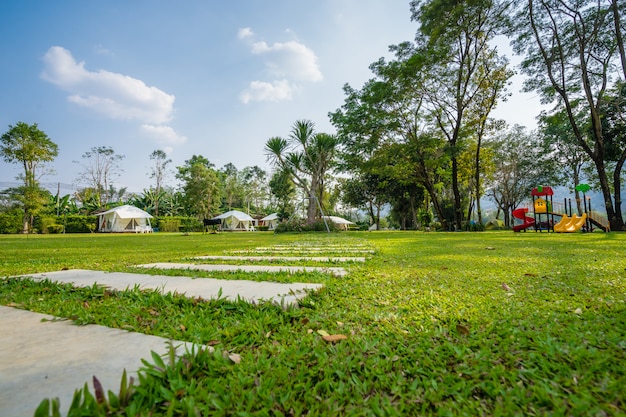 Der Fußweg auf grünen Rasenflächen und Zelt im Garten