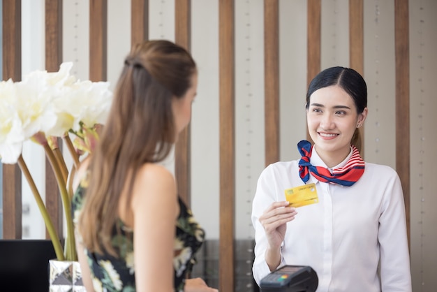 Der Gast bezahlt die Karte für Dienstleistungen am Check-in-Schalter des Hotels, Kunden checken in ein Resort ein