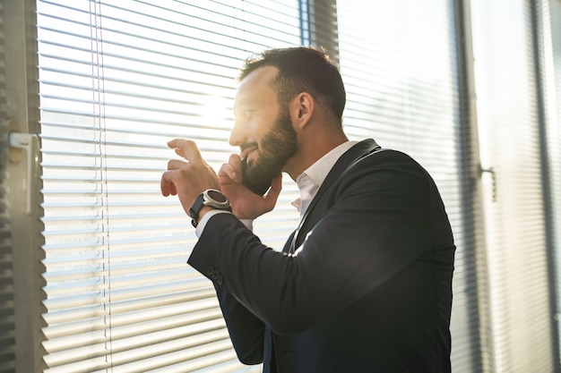 Der Geschäftsmann telefoniert fast blind am Fenster