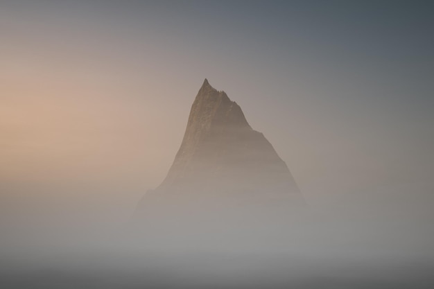 Der Gipfel des Berges erhebt sich aus dem Nebel. Bergthema