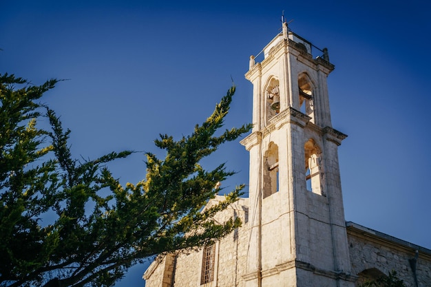 Der Glockenturm der alten Kirche gegen den blauen Himmel