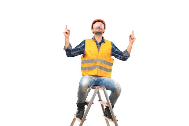 Der glückliche Ingenieur sitzt auf der Leiter auf dem weißen Hintergrund