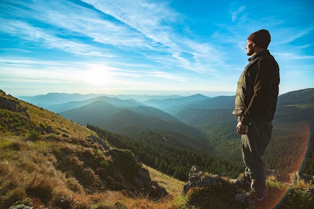 Der glückliche Mann, der auf dem Felsen steht