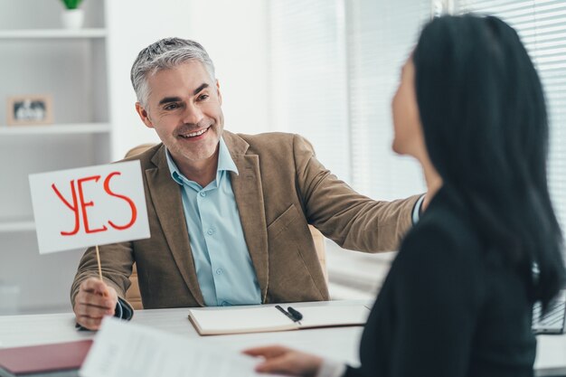 Der glückliche Mann und die glückliche Frau interviewen im Büro