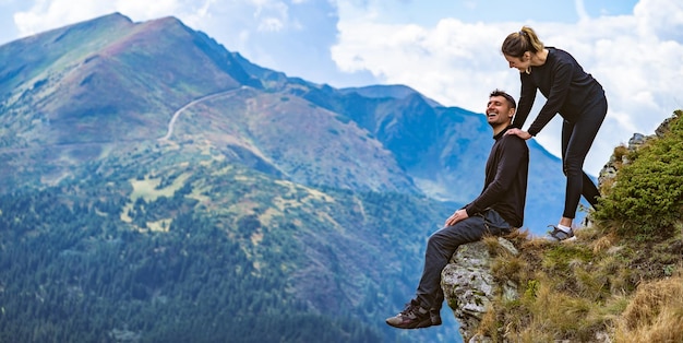 Der glückliche Mann und eine Frau genießen auf der schönen Klippe