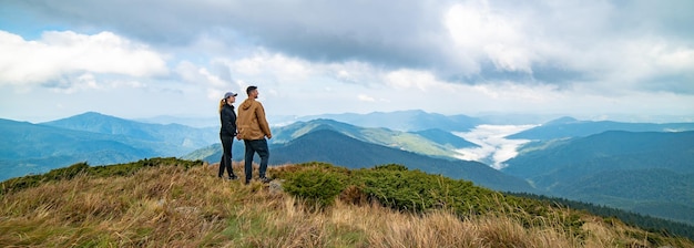 Der glückliche Mann und eine Frau stehen auf einem Berg