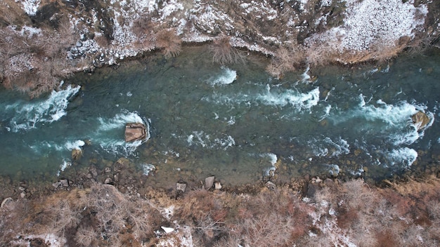 Der Grand Canyon in der Steppe mit dem Emerald River. Ein Riss im Boden mit schwarzen Steinen