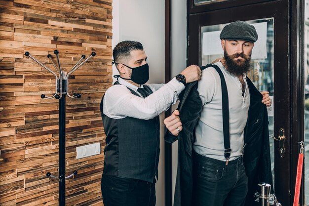 Der gutaussehende Hipster-Mann verlässt den Friseursalon zufrieden. Trendiges und stylisches Bartstyling und -schnitt.