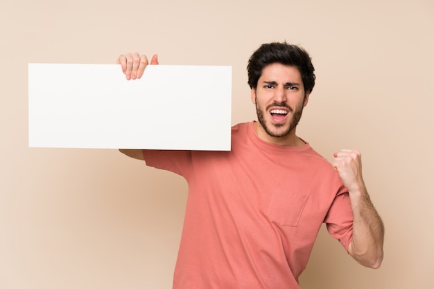 Der gutaussehende Mann, der ein leeres weißes Plakat für hält, fügen ein Konzept ein