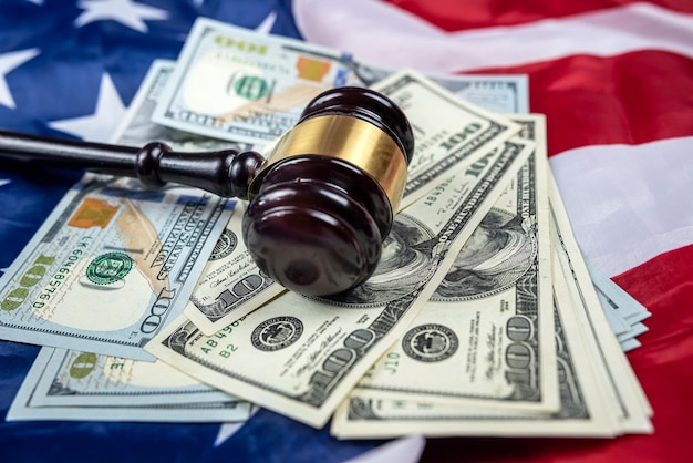 Der Hammer wird zusammen mit Dollars auf dem Hintergrund der Flagge der Vereinigten Staaten von Amerika platziert, Symbol der Gerichtsbarkeit Bestechungsgelder im Justizsystem des Landes