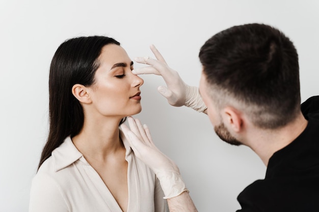 Der HNO-Arzt berührt die Nase und konsultiert eine Patientin in der medizinischen Klinik vor der Septumplastik. Die Nasenkorrektur verändert die Nasenoperation, um das Aussehen der Nase zu verändern und die Atmung zu verbessern