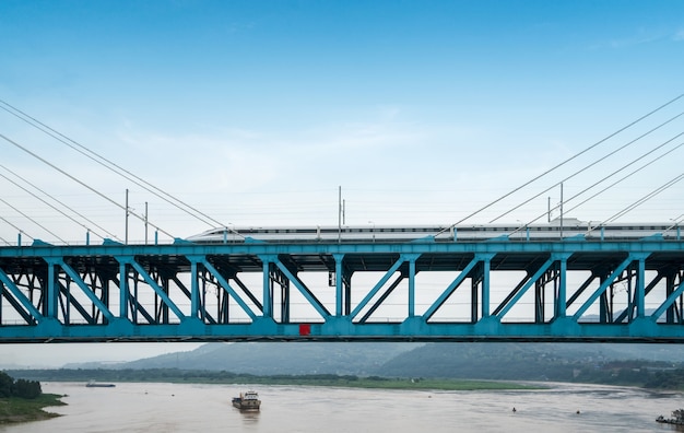 Der Hochgeschwindigkeitszug fährt mit hoher Geschwindigkeit auf der Eisenbahnbrücke.