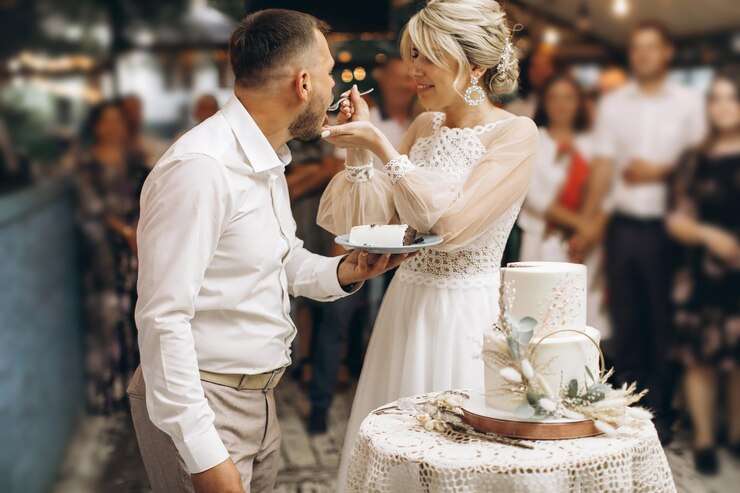 Foto der hochzeitskuchen die braut und der bräutigam schneiden ein stück kuchen mit einem messer ab, die hände der jungvermählten schnitten das erste stück des hochzeitkuches.