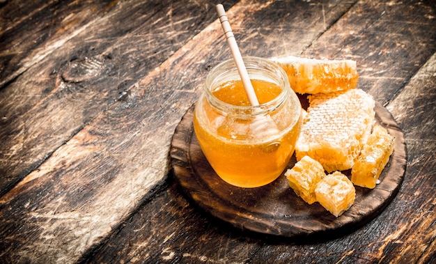 Der Honig im Glas mit den Nüssen auf Holztisch.