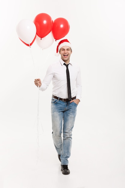 Foto der hübsche glückliche geschäftsmann, der mit rotem ballon geht, feiern weihnachten