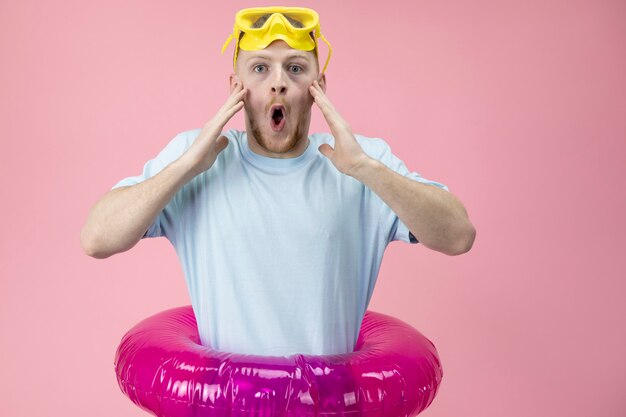 Der hübsche junge Mann in einer gelben Schwimmmaske ist sehr überrascht