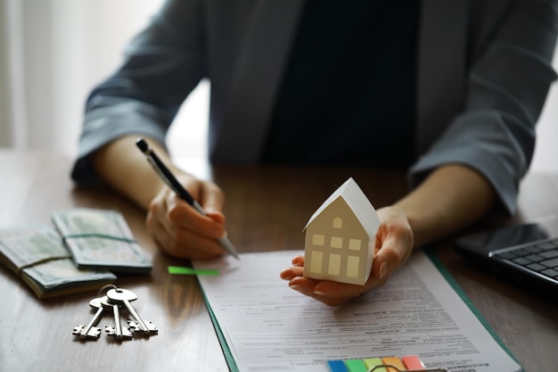 Der Immobilienmakler besprach die Bedingungen des Hauskaufvertrags und bat den Kunden, die Dokumente Hausverkauf und Versicherungskonzept zu unterzeichnen