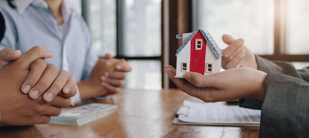 Der Immobilienmakler erstellt einen Hausvertrag, nachdem der Kunde die Kaution für das Haus bezahlt hat, Verhandlung, Abschluss des Geschäfts