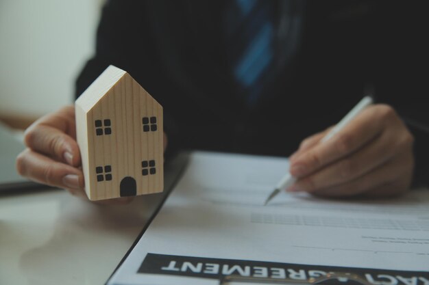 Der Immobilienmakler sprach über die Bedingungen des Hauskaufvertrags und bat den Kunden, die Dokumente zu unterschreiben, um den Vertrag rechtsgültig zu machen. Hausverkaufs- und Hausversicherungskonzept