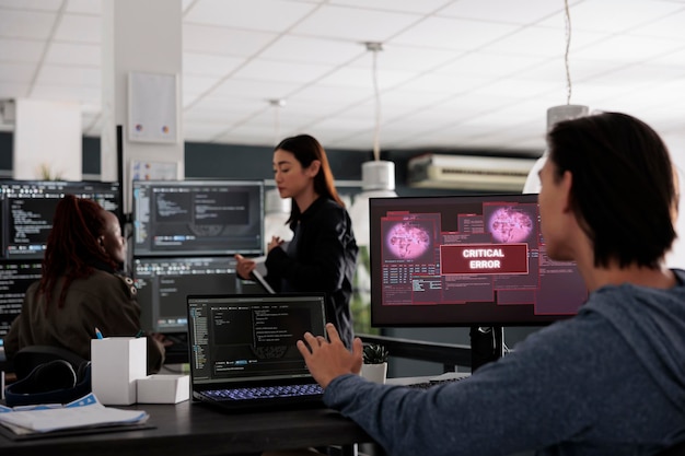 Der Ingenieur betrachtet den Monitor beim Lesen kritischer Fehler in seiner Big-Data-Agentur und wird gehackt. App-Entwickler, der mit Code für künstliche Intelligenz und Serverdatenbank arbeitet, um das Hacken von Programmen zu stoppen.