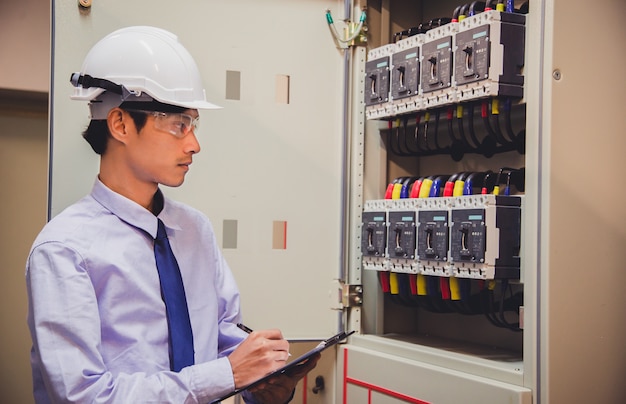 Der Ingenieur prüft die Spannung oder den Strom mit einem Voltmeter im Bedienfeld des Kraftwerks.