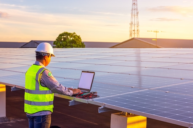 Der Ingenieur überprüft die Solarzellen-Photovoltaik-Kraftwerksanlage auf dem Dach.