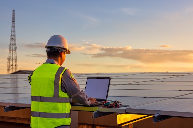 Der Ingenieur überprüft die Solarzellen-Photovoltaik-Kraftwerksanlage auf dem Dach.