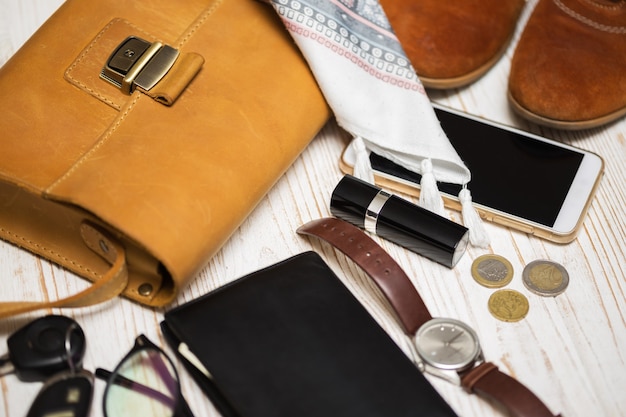 Der Inhalt der Damenhandtasche - Geldbörse, Schlüssel, Telefon, Lippenstift, Uhr, Geld, Accessoires