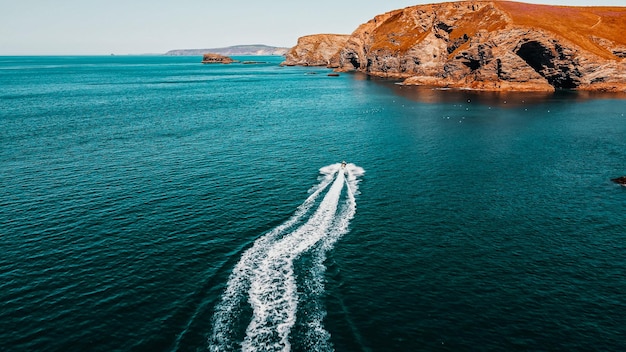 Der Jetski fährt in Richtung des Felsens auf türkisfarbenem Wasser Luftaufnahme