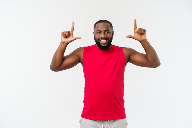 Der junge Afroamerikanersportmann, der Finger mit überrascht zeigt, fühlt sich erfolgreich und wohlhabend