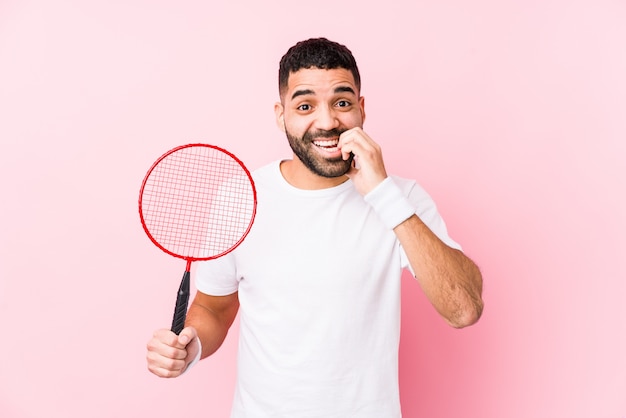 Der junge arabische Mann, der Badminton spielt, lokalisierte die beißenden Fingernägel, nervös und sehr besorgt.