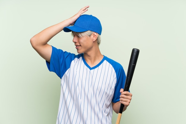 Der junge asiatische Mann, der Baseball über lokalisiertem Grün spielt, hat etwas verwirklicht und die Lösung beabsichtigt