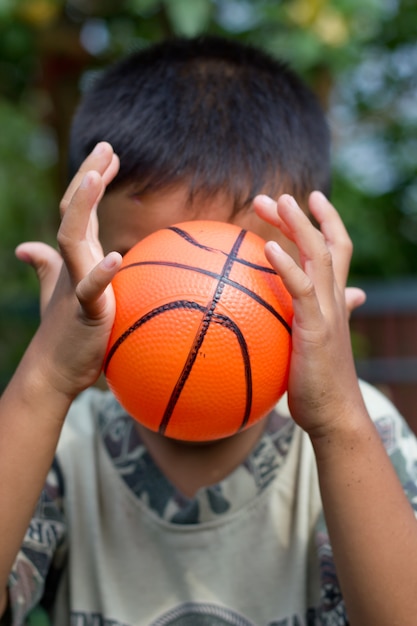 Der Junge, der Ball in seiner Hand hält.