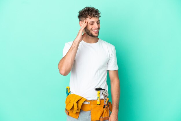 Der junge Elektriker, blonder Mann, der auf grünem Hintergrund isoliert ist, hat etwas erkannt und beabsichtigt die Lösung