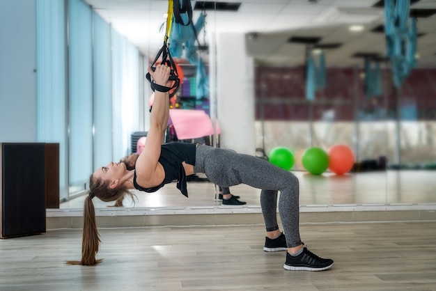 Der junge Fitnesstrainer wärmt sich vor dem Training im Fitnessstudio auf