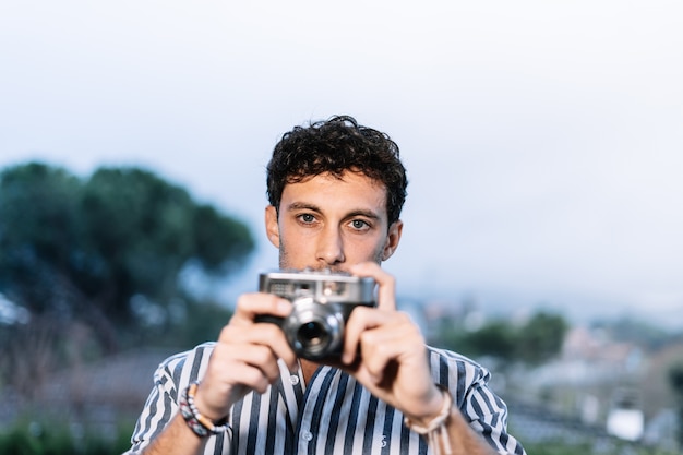 Der junge Fotograf macht ein Foto mit einer Retro-Kamera