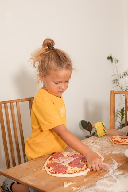 Der Junge freute sich, Pizza mit seinen eigenen Händen zu kochen