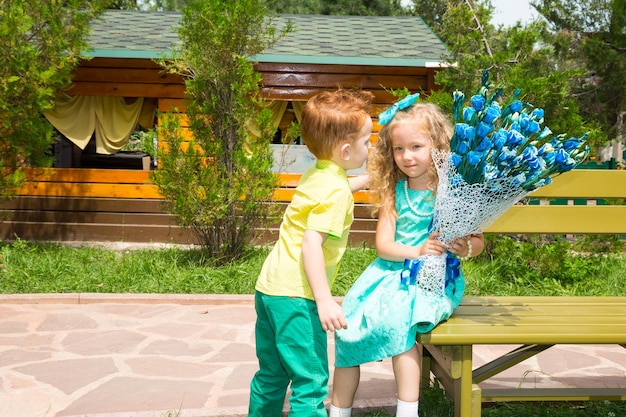Der Junge gibt einem Mädchen eine Blume zum Geburtstag Feierkonzept und Kindheitsliebe